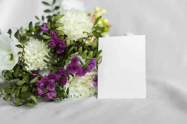 Postcard with a flowers and an empty tag for text. Romantic greeting and surprise. Concept of love, birthday, Happy mother's Day and Valentine's Day on white background. Selective focus. copy space