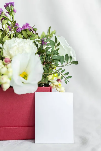 Postcard with a flowers and an empty tag for text. Romantic greeting and surprise. Concept of love, birthday, Happy mother's Day and Valentine's Day on white background. Selective focus. copy space
