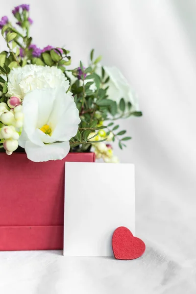 Postal con flores y etiqueta vacía para texto. Saludo romántico y sorpresa. Concepto de amor, cumpleaños, Feliz Día de la Madre y Día de San Valentín sobre fondo blanco. Enfoque selectivo. espacio de copia —  Fotos de Stock