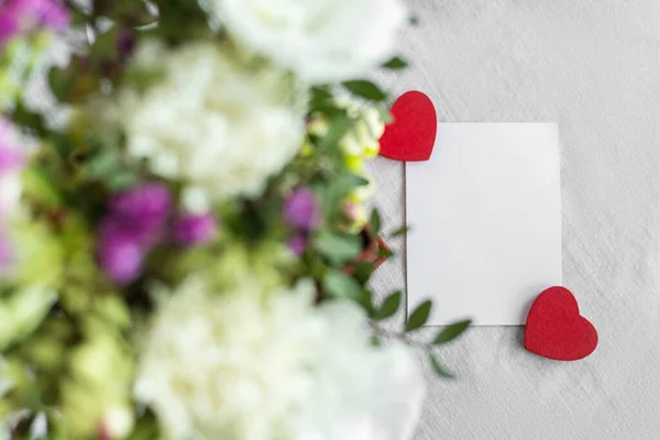 İçinde çiçekler, kalp ve mesaj için boş bir etiket olan bir kartpostal. Romantik selamlama ve sürpriz. Aşk kavramı, beyaz arka planda Anneler Günü ve Sevgililer Günü 'n kutlu olsun. Seçici odaklanma. Boşluğu kopyala