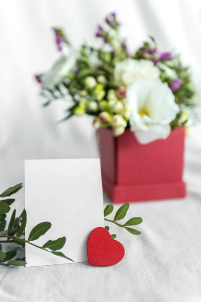 İçinde çiçekler, kalp ve mesaj için boş bir etiket olan bir kartpostal. Romantik selamlama ve sürpriz. Aşk kavramı, beyaz arka planda Anneler Günü ve Sevgililer Günü 'n kutlu olsun. Seçici odaklanma. Boşluğu kopyala