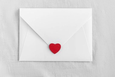 Beyaz arka planda kalpleri olan bir zarf. Düğün davetiyesi ya da aşk mektubu. Aşk konsepti, Anneler Günün ve Sevgililer Günün kutlu olsun. Yukarıdan görünüm.