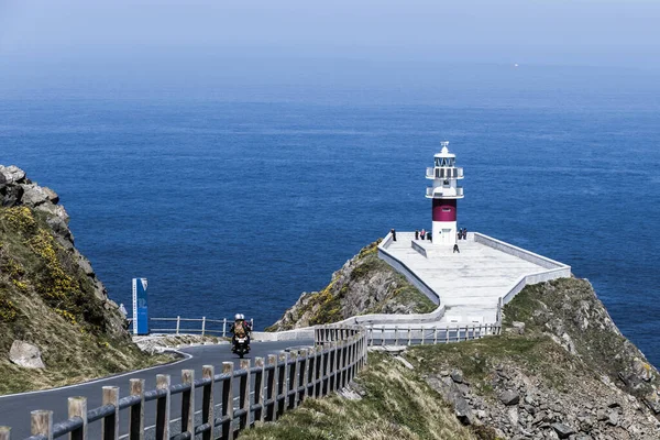 Yolun sonundaki deniz fenerinde. Motosikletli.