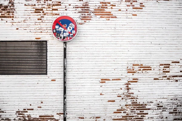 Duvardaki çıkartmalarla dolu yasak tabela.