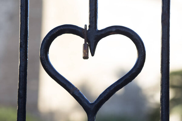 Forged iron heart with rusty padlock hanging