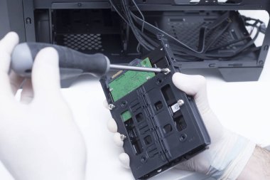 Bilgisayar donanımı parçaları birleştiren bir teknisyenin elleri. Sabit disk yeni bir bilgisayara yükleniyor