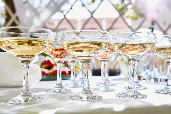 Row of glasses filled with champagne are lined up ready to be served. — Stock fotografie