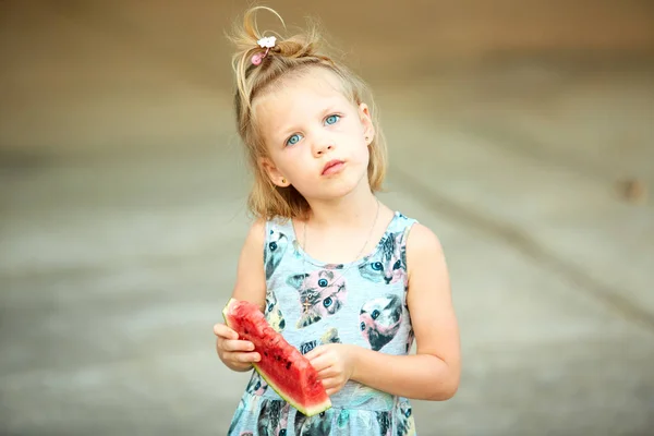 かわいいブロンドの女の子を食べるスイカ屋外のスライス. — ストック写真