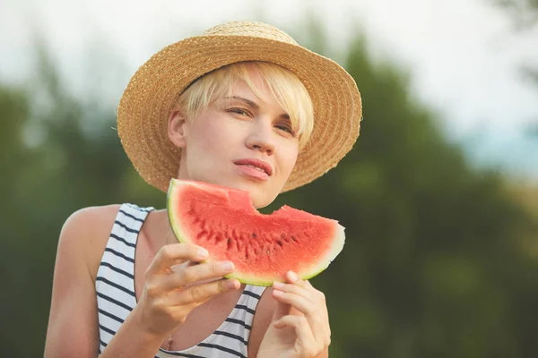 Beautiful girl in straw hat eating fresh watermelon. Film camera style — Stock Photo, Image