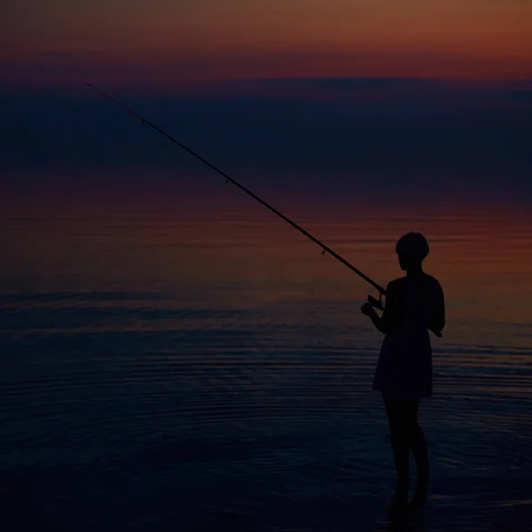 Fishing Silhouette on dramatic sky and sea Stock Image