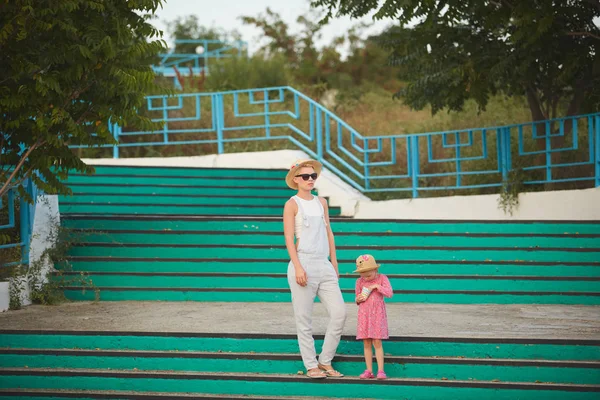 Hipster mom in straw hat with daughter barefoot. Film style — Stock Photo, Image