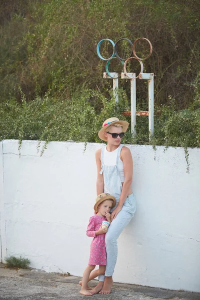 时髦妈妈在女儿赤脚的草帽。电影风格 — 图库照片