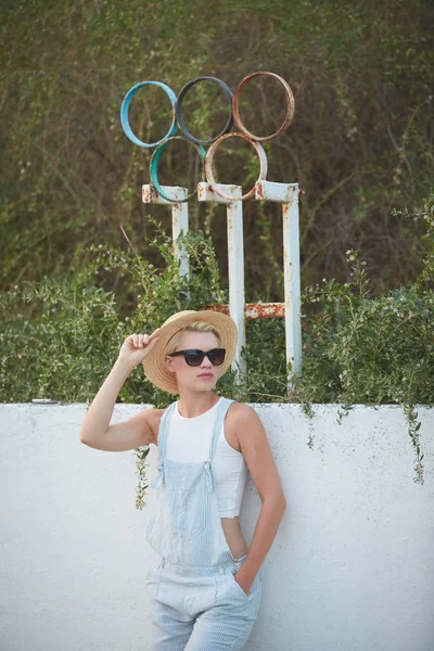 Bastante delgado bronceado rubia elegante mujer en sombrero de paja y gafas de sol posando — Foto de Stock