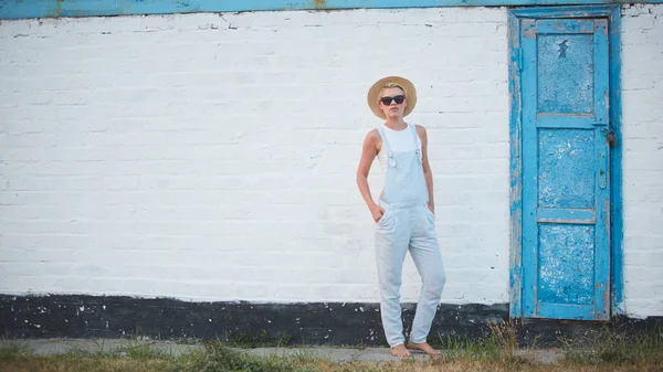 Ganska smal solbränna blond snygg kvinna i stråhatt och solglasögon poserar — Stockfoto