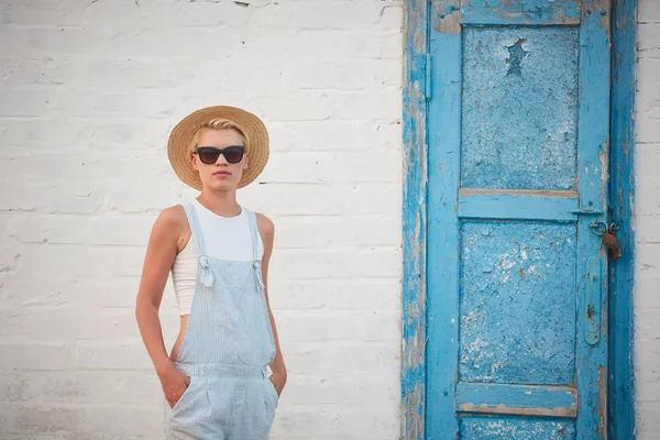 Bastante delgado bronceado rubia elegante mujer en sombrero de paja y gafas de sol posando — Foto de Stock