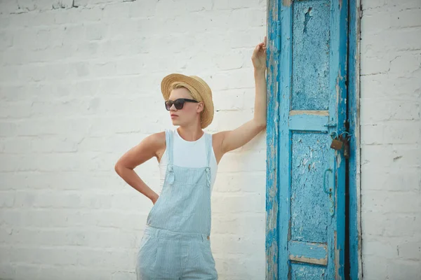 Bastante delgado bronceado rubia elegante mujer en sombrero de paja y gafas de sol posando — Foto de Stock