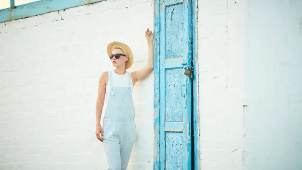 Bastante delgado bronceado rubia elegante mujer en sombrero de paja y gafas de sol posando — Foto de Stock