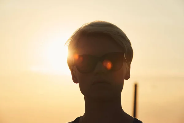 Retrato de una mujer joven en la noche con rayos de sol filtrándose a través de ella — Foto de Stock