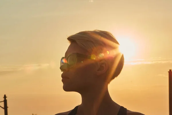 Portrait of a young woman in evening with sun rays filtering through her — Stock Photo, Image