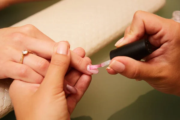 Крупный план женщины в маникюре, получающей маникюр от косметолога с пилкой для ногтей. Женщине делают маникюр. Мбаппе придирается к клиенту — стоковое фото