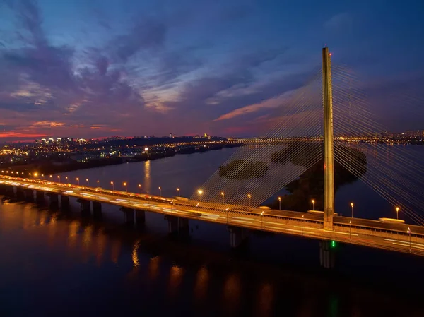 Samochodowe i kolejowe most w Kijowie, stolicy Ukrainy. Most o zachodzie słońca po drugiej stronie rzeki Dniepr. Kijów most na tle pięknego zachodu słońca w Kijowie. Most w wieczorne słoneczko — Zdjęcie stockowe