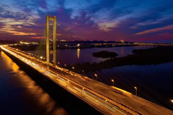 Automóvel e ponte ferroviária em Kiev, a capital da Ucrânia. Ponte ao pôr-do-sol do outro lado do rio Dnieper. Kiev ponte contra o pano de fundo de um belo pôr do sol em Kiev. Ponte na luz do sol da noite — Fotografia de Stock