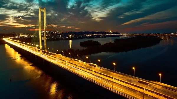 Automobiel- en spoorweg-brug in Kiev, de hoofdstad van Oekraïne. Brug bij zonsondergang over de rivier de Dnjepr. Kiev brug tegen de achtergrond van een prachtige zonsondergang in Kiev. Brug in de avondzon — Stockfoto