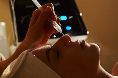 Yüz güzellik bakımı. Tatlı güzel kadının yüz gaz-sıvı oksijen su Epidermal kozmetik merkezinde profesyonel ekipman kullanarak Peeling Başlarken. Cilt bakım kavramı.