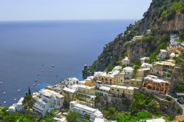 One of the best resorts of Italy with old colorful villas on the steep slope, nice beach, numerous yachts and boats in harbor and medieval towers along the coast, Positano. clipart