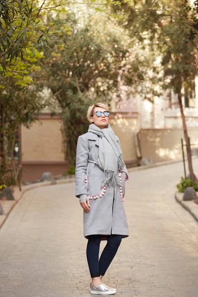 Jeune femme blonde avec des lunettes de soleil dans la rue — Photo