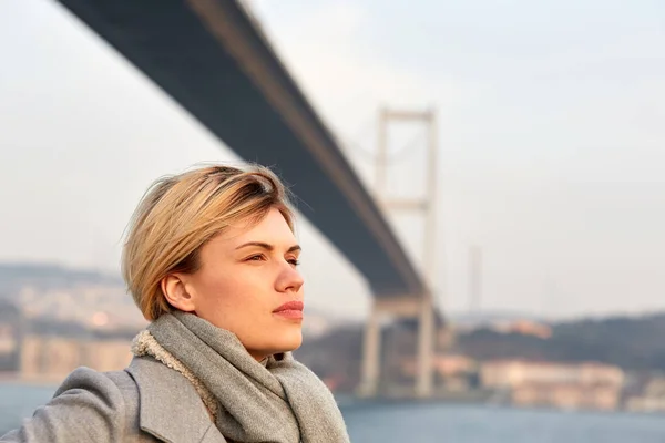 Boğaziçi Köprüsü altında genç bir kadın portresi. — Stok fotoğraf