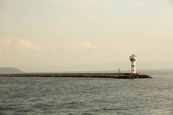 灯台と美しい海の風景。穏やかな海と桟橋の灯台。無限の海で小さなビーコン。風景し、ビーコンします。灯台 — ストック写真