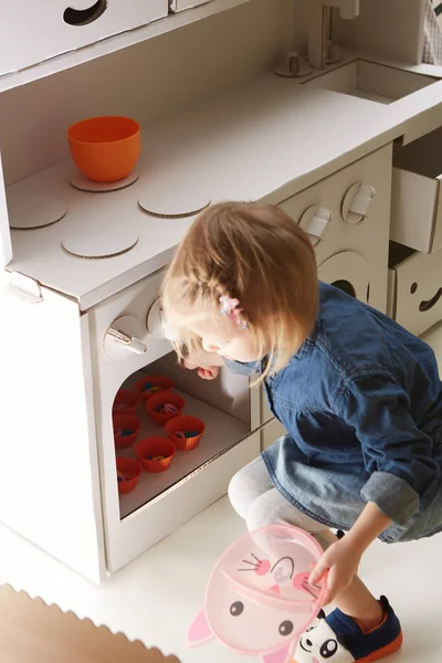 Niña jugando con la cocina de juguete en casa — Foto de Stock