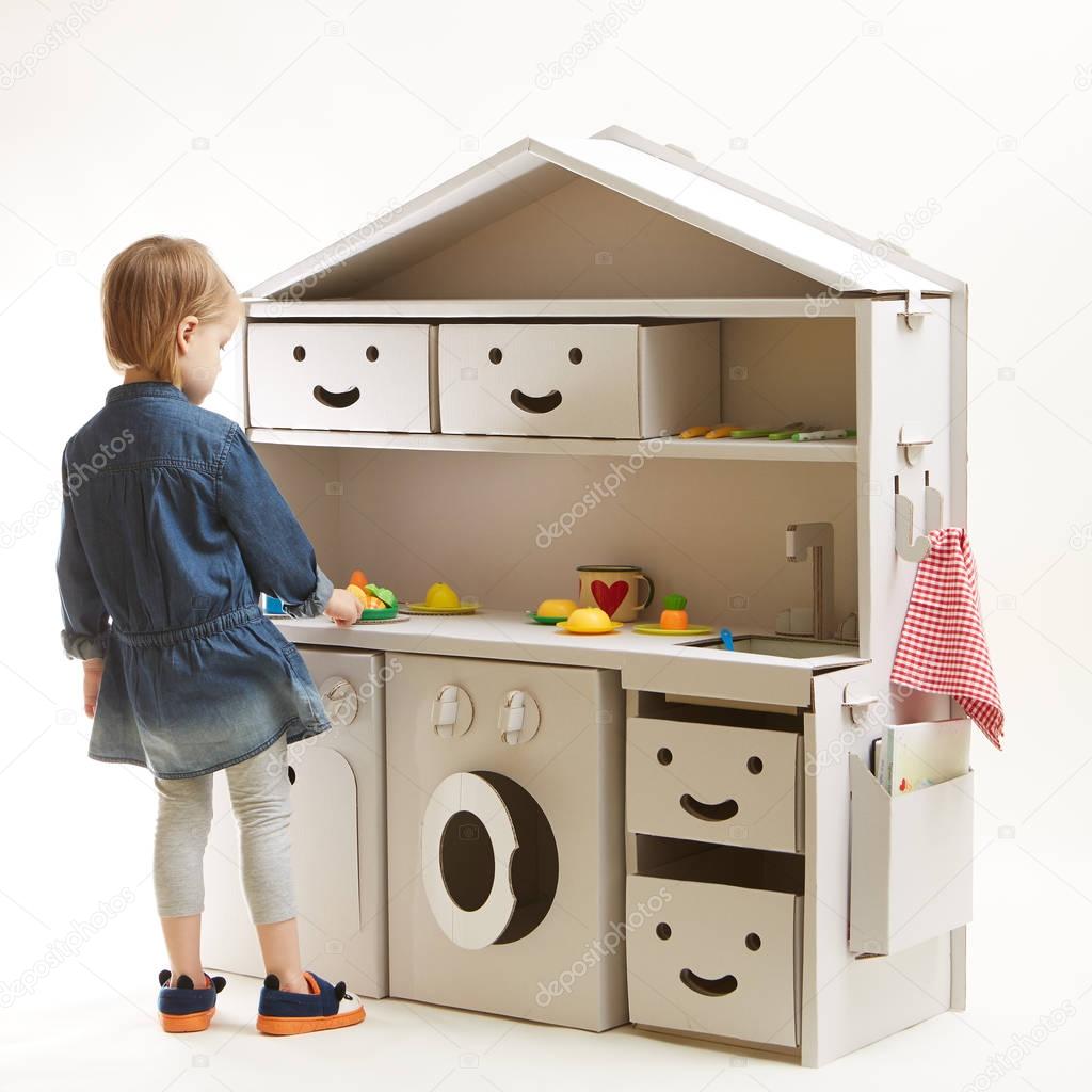 toddler girl playing with toy kitchen at home