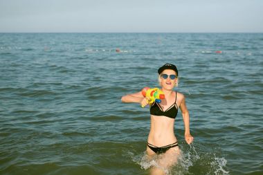 Bir kap su tabancası ile oynarken kelime Kraliçe ile mutlu bir genç kadın. Film etkisi