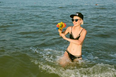 Bir kap su tabancası ile oynarken kelime Kraliçe ile mutlu bir genç kadın. Film etkisi