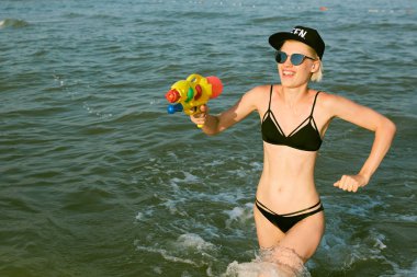 Bir kap su tabancası ile oynarken kelime Kraliçe ile mutlu bir genç kadın. Film etkisi