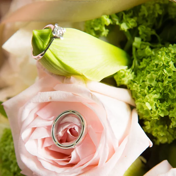 结婚戒指躺在一束漂亮的花束上作为新娘的饰物 — 图库照片