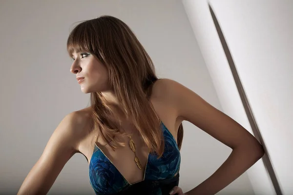 エレガントな青いドレスで官能的な女性の素敵な肖像画。室内でポージング. — ストック写真