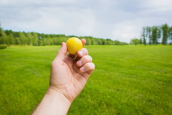 Mano con pelota de golf sobre un campo de golf —  Fotos de Stock