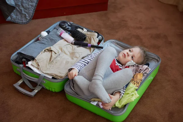 Aranyos kis gyermek belsejében egy nagy bőröndre. — Stock Fotó
