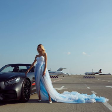 Kyiv, Ukrayna - 2 Eylül 2017: Havalimanında Mercedes Benz Amg GT 50 modelli spor arabanın yanında poz veren zarif sarışın güzel kadın. 50. yıldönümünü kutlamak için tasarlanmış yeni bir 2017 süper arabası.