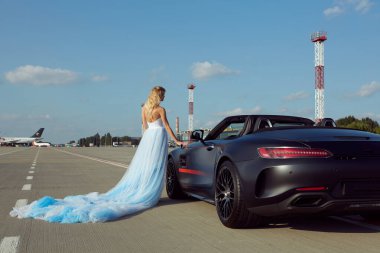 Kyiv, Ukrayna - 2 Eylül 2017: Havalimanında Mercedes Benz Amg GT 50 modelli spor arabanın yanında poz veren zarif sarışın güzel kadın. 50. yıldönümünü kutlamak için tasarlanmış yeni bir 2017 süper arabası.