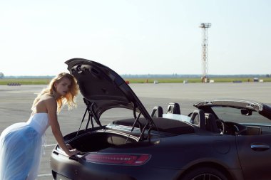 Kyiv, Ukrayna - 2 Eylül 2017: Havalimanında Mercedes Benz Amg GT 50 modelli spor arabanın yanında poz veren zarif sarışın güzel kadın. 50. yıldönümünü kutlamak için tasarlanmış yeni bir 2017 süper arabası.