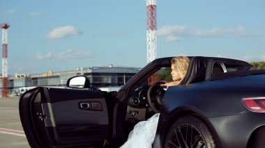 Kyiv, Ukrayna - 2 Eylül 2017: Havalimanında Mercedes Benz Amg GT 50 modelli spor arabanın yanında poz veren zarif sarışın güzel kadın. 50. yıldönümünü kutlamak için tasarlanmış yeni bir 2017 süper arabası.