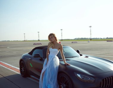 Kyiv, Ukrayna - 2 Eylül 2017: Havalimanında Mercedes Benz Amg GT 50 modelli spor arabanın yanında poz veren zarif sarışın güzel kadın. 50. yıldönümünü kutlamak için tasarlanmış yeni bir 2017 süper arabası.