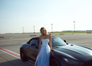 Kyiv, Ukrayna - 2 Eylül 2017: Havalimanında Mercedes Benz Amg GT 50 modelli spor arabanın yanında poz veren zarif sarışın güzel kadın. 50. yıldönümünü kutlamak için tasarlanmış yeni bir 2017 süper arabası.