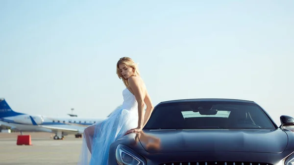 Kiev, Ucrania - 2 de septiembre de 2017: La hermosa mujer rubia elegante posando cerca de Mercedes Benz AMG GT 50 Edition coche deportivo en el aeropuerto. Un nuevo superdeportivo 2017 diseñado para celebrar el 50 aniversario — Foto de Stock