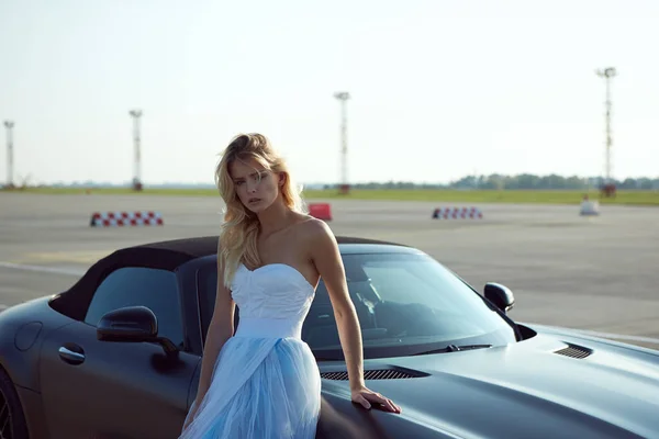 Kiev, Ucraina - 2 septembrie 2017: elegant blonda frumoasa femeie pozand langa Mercedes Benz AMG GT 50 Edition masina sport in aeroport. Un nou supercar 2017 conceput pentru a sărbători 50 de ani — Fotografie, imagine de stoc