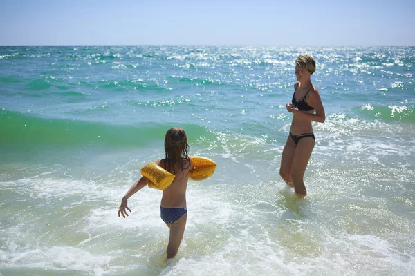 夏幸せな家族の6年ブロンド子供遊びとジャンプ水波包含する女性母で海の海岸ビーチ — ストック写真